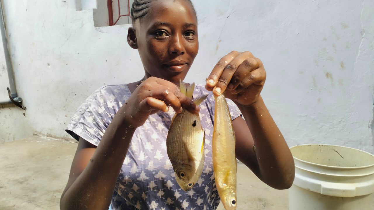 Sharon Kasiwa holding fresh fish in market